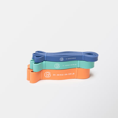 Flex-Fitnessbänder aufgewickelt in blau, türkis und orange mit Gymondo-Logo
